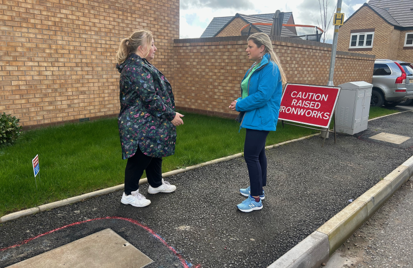 Hannah and Councillor discuss the unmade roads and pavements in a new development