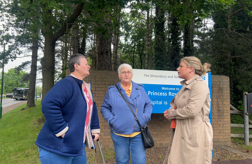 Hannah with residents next to the Princess Royal Hospital sign discussing their experiences. 