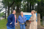 Hannah with residents next to the Princess Royal Hospital sign discussing their experiences. 